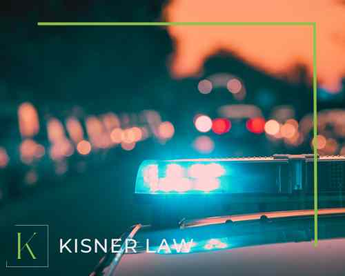 Image of a police car blue and red lights in the rear view mirror.  Choose Jason Kisner, a car accident attorney,